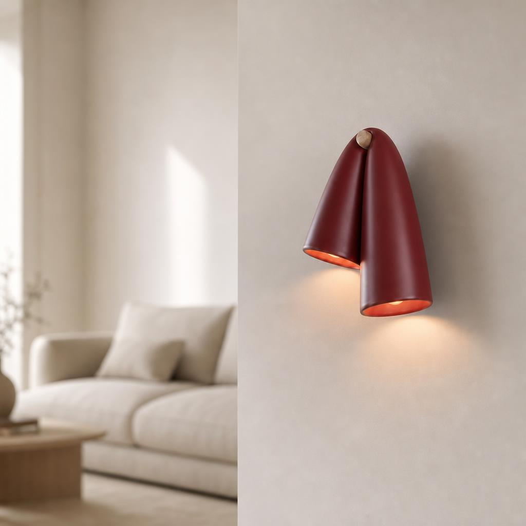 Burgundy ceramic wall sconce mounted on a neutral wall in a styled modern interior